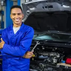 smiling-mechanic-with-arms-crossed-spanner-scaled-1-r7vbdvj7gx7eg1ugby0mhdelj9h5ism6dfq3w2h9hg